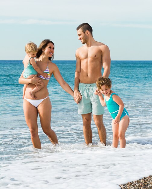 Família de quatro na praia