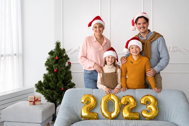Família de quatro pessoas comemorando a véspera de ano novo em casa juntos