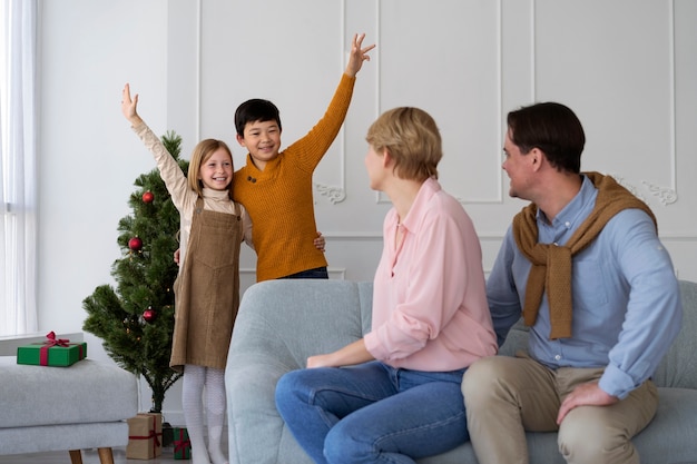 Família de quatro pessoas comemorando a véspera de ano novo em casa juntos