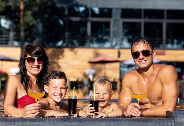 Família de quatro pessoas curtindo um dia na piscina juntos