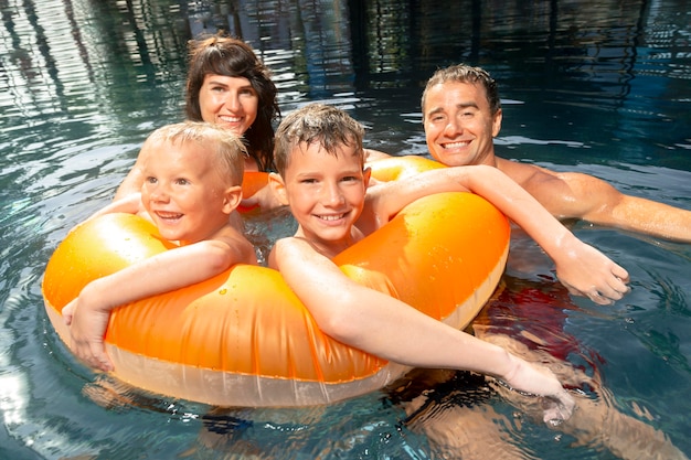 Família de quatro pessoas curtindo um dia na piscina juntos