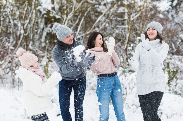 Família de rir na floresta de inverno