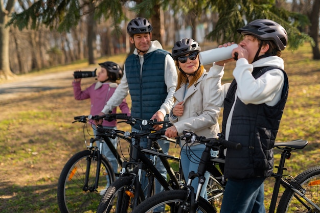 Família de tiro completo andando de bicicleta juntos