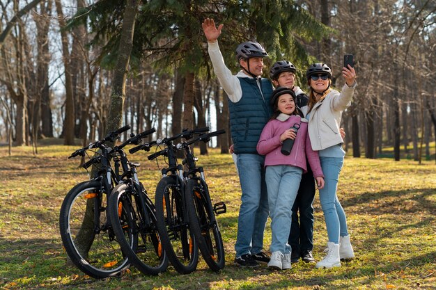 Família de tiro completo andando de bicicleta juntos