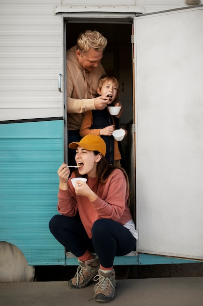 Família de tiro completo comendo ao ar livre