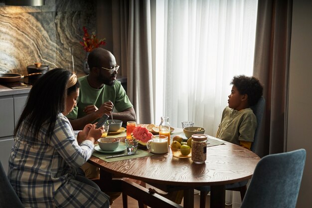 Família de tiro médio comendo junta