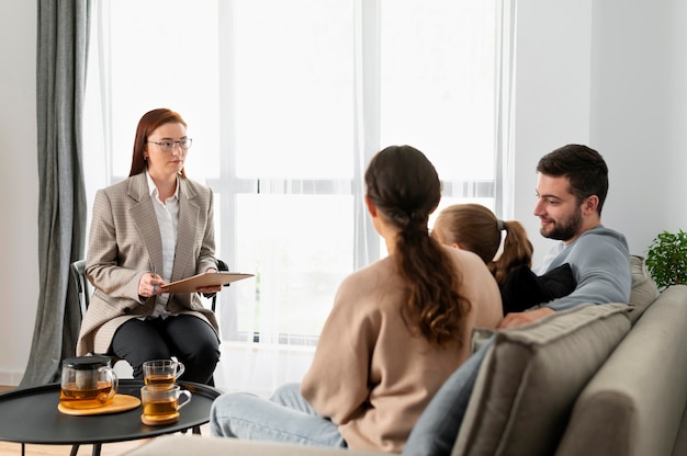 Família de tiro médio discutindo com terapeuta