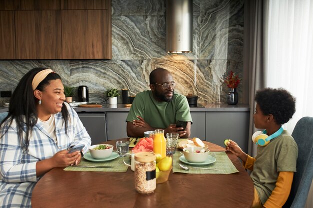 Família de tiro médio sentado à mesa