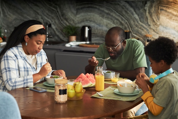 Foto grátis família de tiro médio sentado à mesa