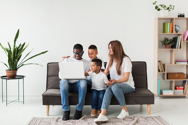 Família de tiro no escuro, olhando em um laptop