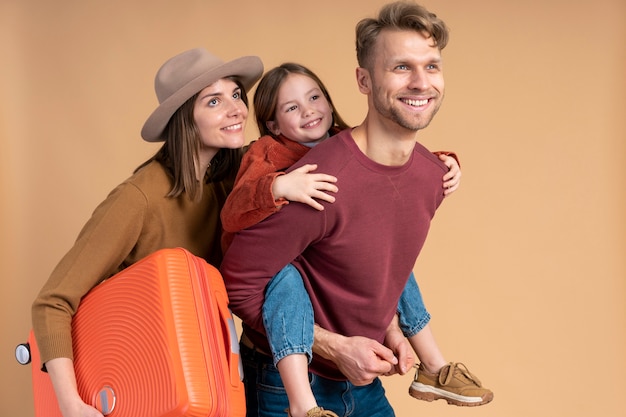 Foto grátis família de três pessoas pronta para uma viagem de férias com bagagem