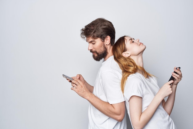 Família de um jovem casal com telefones na mão comunicação luz de fundo