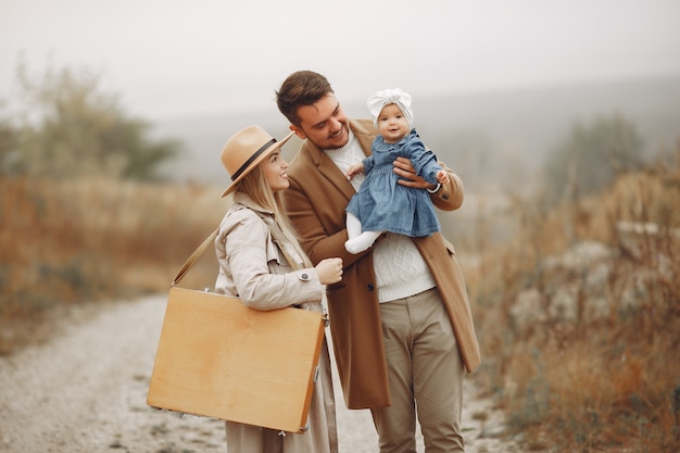 Família elegante andando em um campo de outono