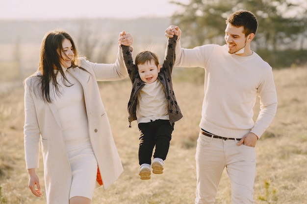 Família elegante andando em um campo ensolarado