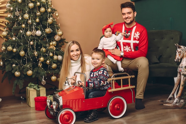 Família em casa perto de árvore de natal