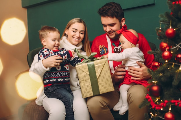 Família em casa perto de árvore de natal