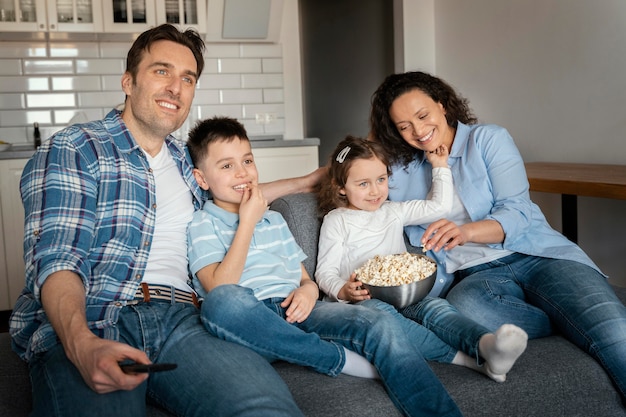 Família em plano médio assistindo televisão