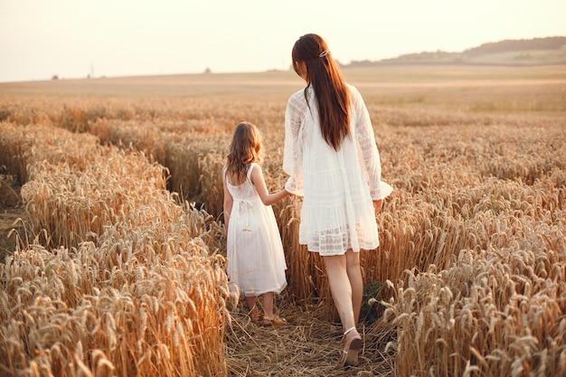 Família em um campo de verão. Foto sensual. Menina bonitinha. Mulher de vestido branco.