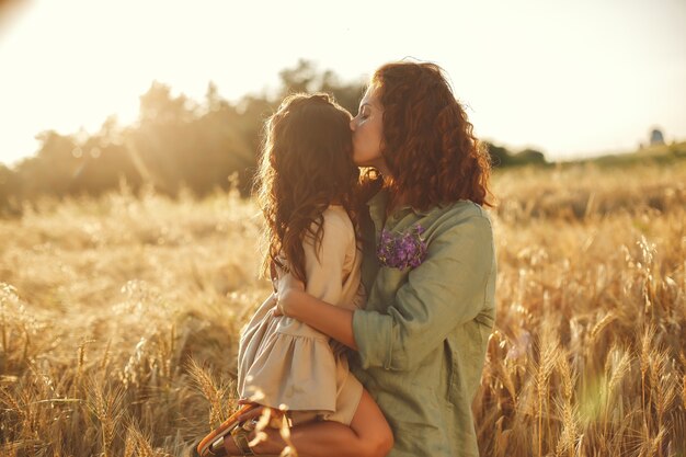 Família em um campo de verão. Foto sensual. Menina bonitinha.