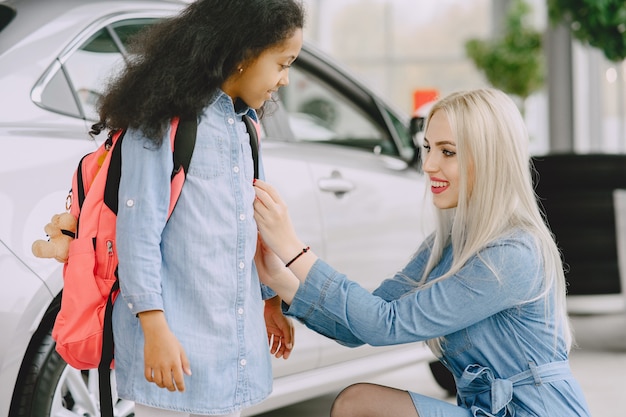 Foto grátis família em um salão de automóveis. mulher comprando o carro. menina africana com mther.