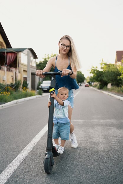 Família feliz andando de scooter no bairro na estrada.