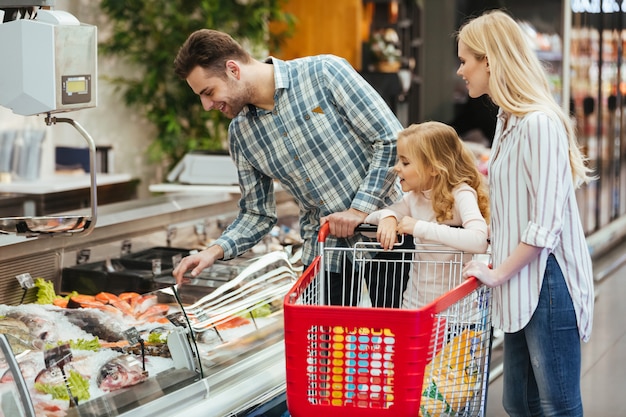 Família feliz com criança comprando comida