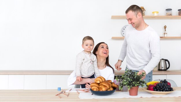 Família feliz com criança na cozinha e copie o espaço