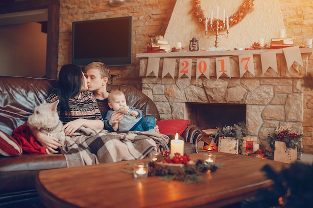 Família feliz com um bebê e um cão e ao seu lado uma chaminé com o cartaz de 2017