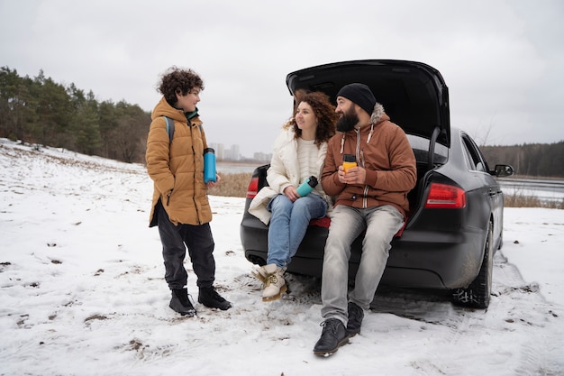 Família feliz de tiro completo com carro