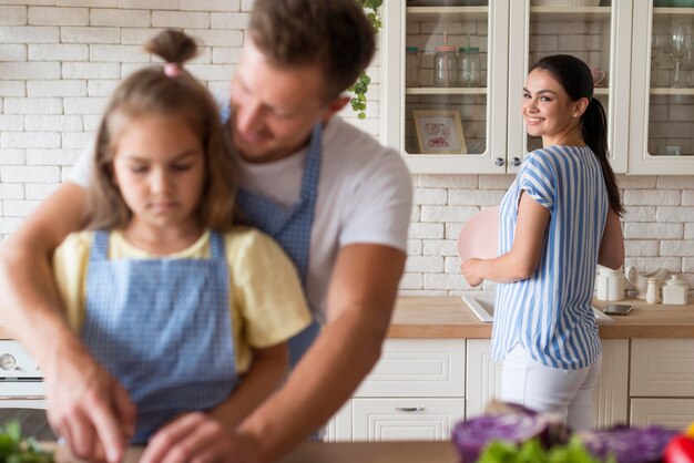 Família feliz de tiro médio na cozinha