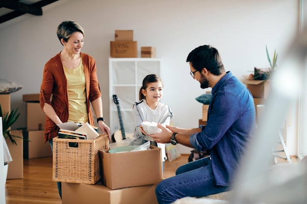 Família feliz desempacotando seus pertences enquanto se muda para uma nova casa