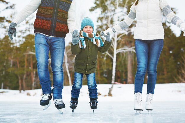 Família feliz na pista de gelo