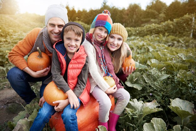 Família feliz no campo cheio de abóbora