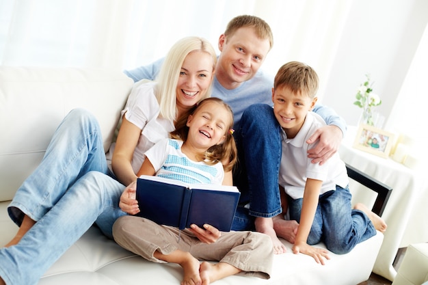 Família feliz que lê um livro