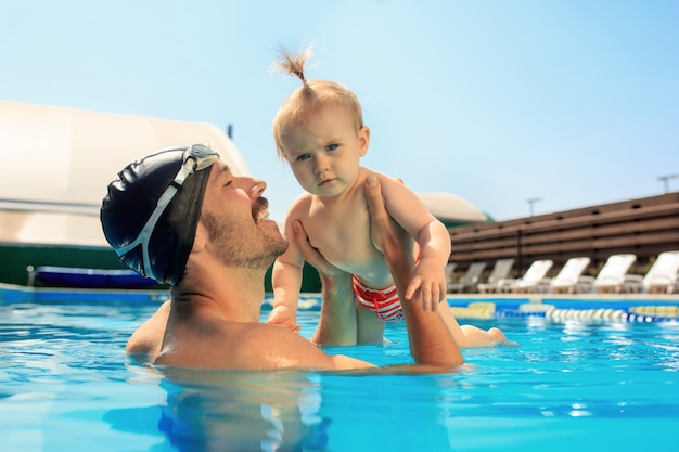 Família feliz se divertindo à beira da piscina.