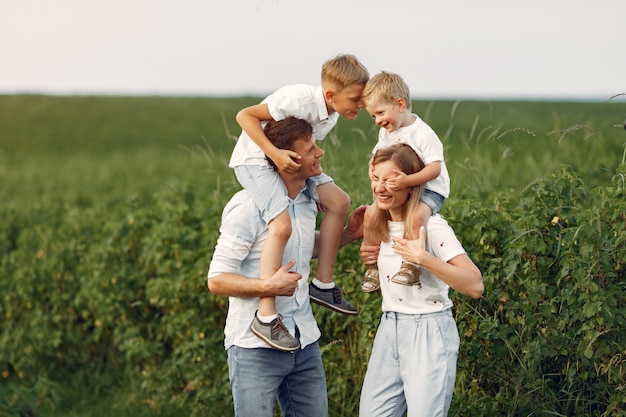 Família fofa brincando em um campo de verão