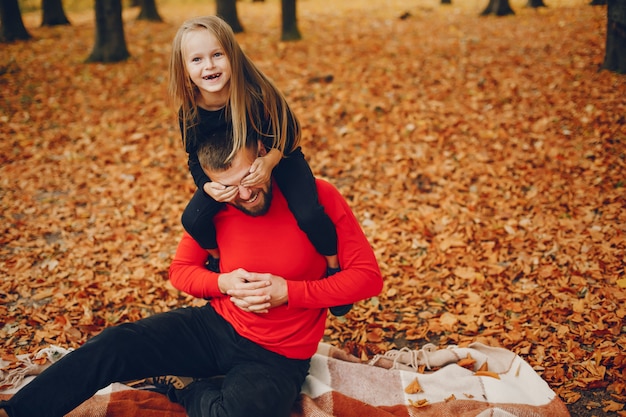 Família fofa brincando em um parque de outono