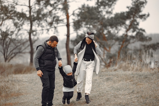 Família fofa brincando em uma floresta de primavera