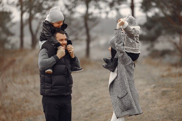 Família fofa brincando em uma floresta de primavera