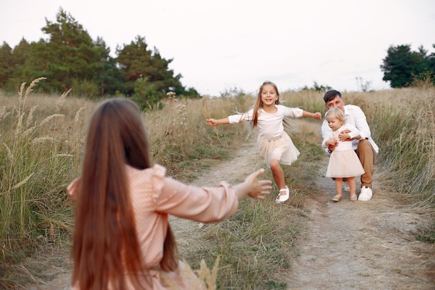 Família fofa jogando em um campo de outono