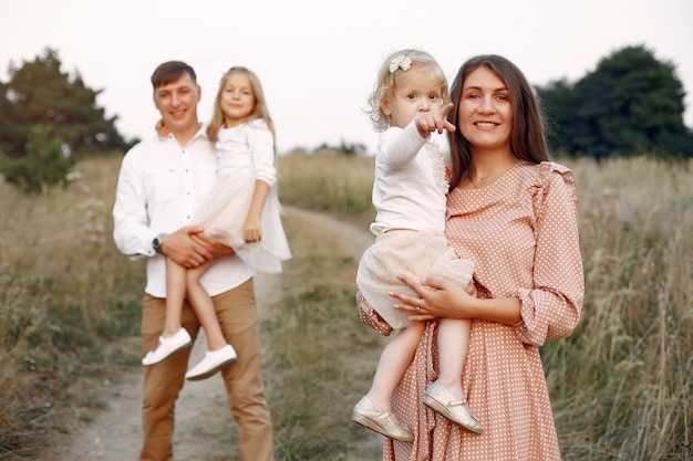 Família fofa jogando em um campo de outono