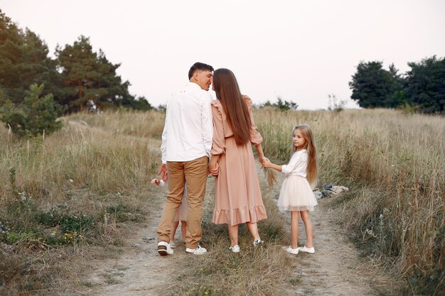 Família fofa jogando em um campo de outono