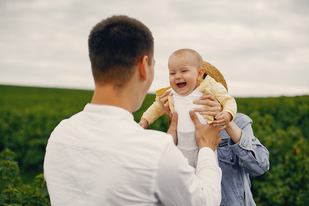 Família fofa jogando em um campo de verão