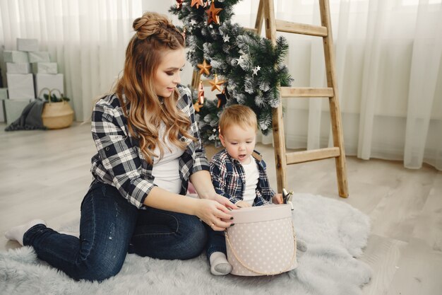 Família fofa sentado perto da árvore de Natal