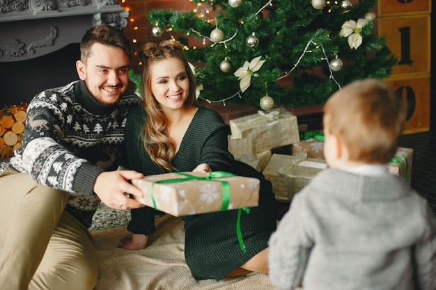 Família fofa sentado perto da árvore de natal