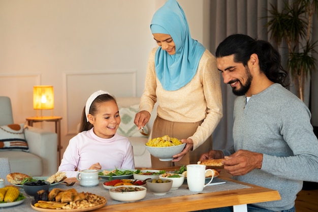 Família islâmica com comida deliciosa de plano médio
