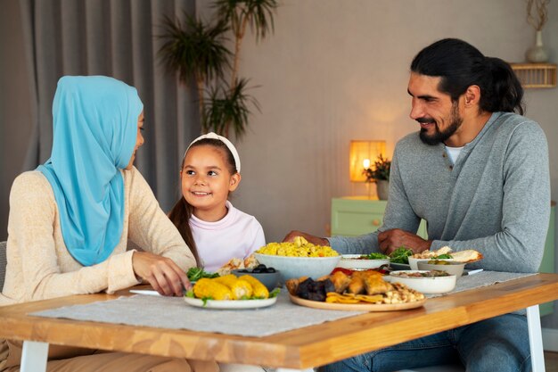 Família islâmica com tiro médio de comida saborosa