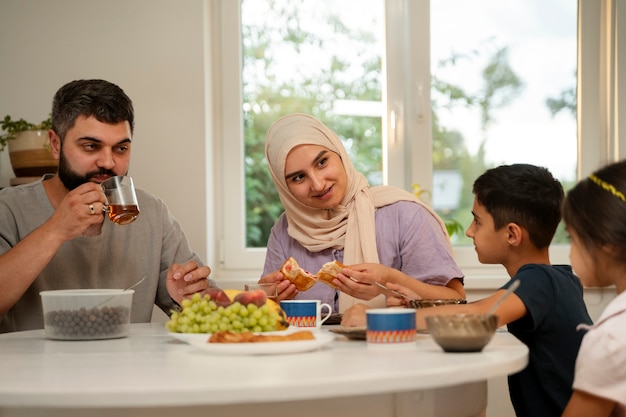 Família islâmica de tiro médio comendo