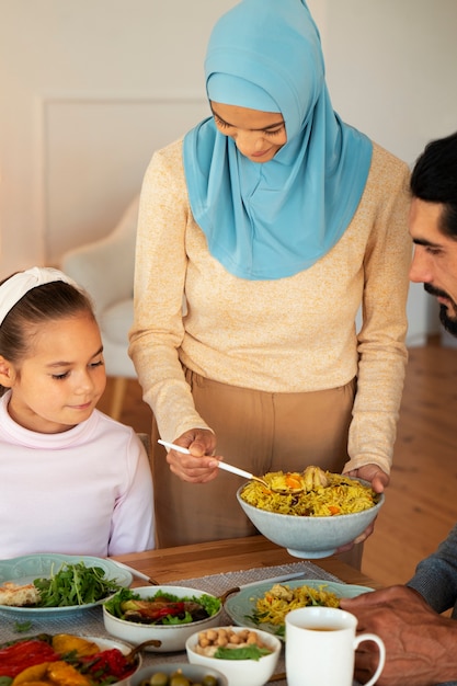 Família islâmica de vista frontal com comida deliciosa