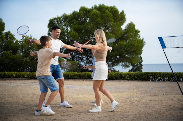 Família jogando badminton tiro completo